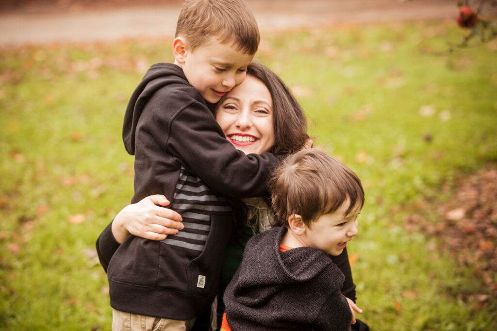 Image of woman hugging two young boys